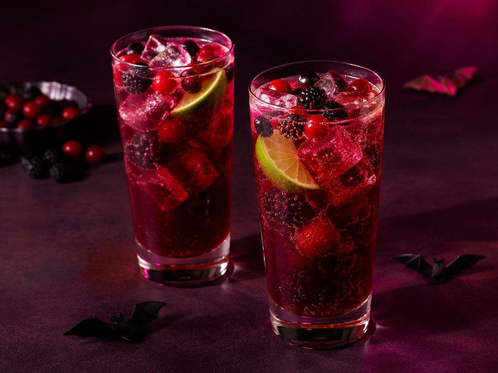Two glasses of sparkling berry spritzer with ice and lime